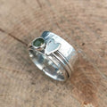 Bred ring i sølvfarve med hjerte og rund grøn sten