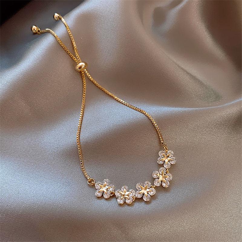 Blomstereng | Justerbart guldfarvet armbånd med krystalblomster – Visning 03