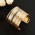 Guldkant | Bred guldfarvet bangle med mange ringe – Visning 01