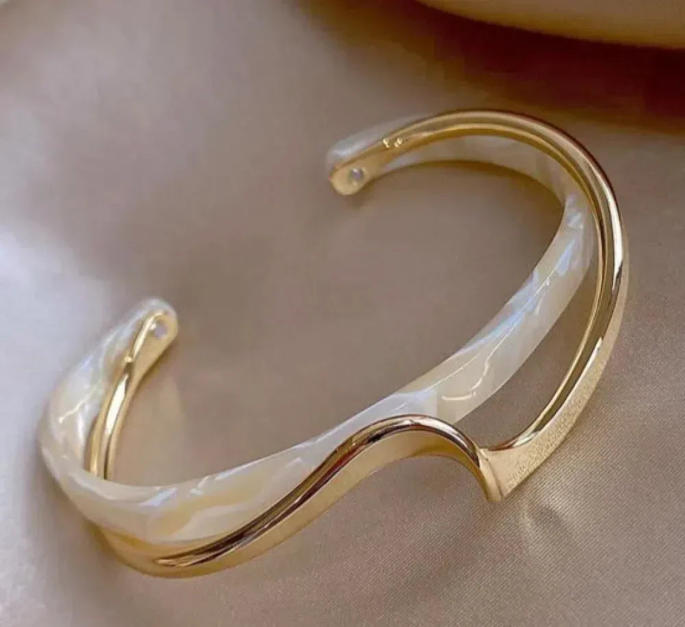 Hvidskær | Guldfarvet bangle med hvid detalje og opallignende skær – Visning 01